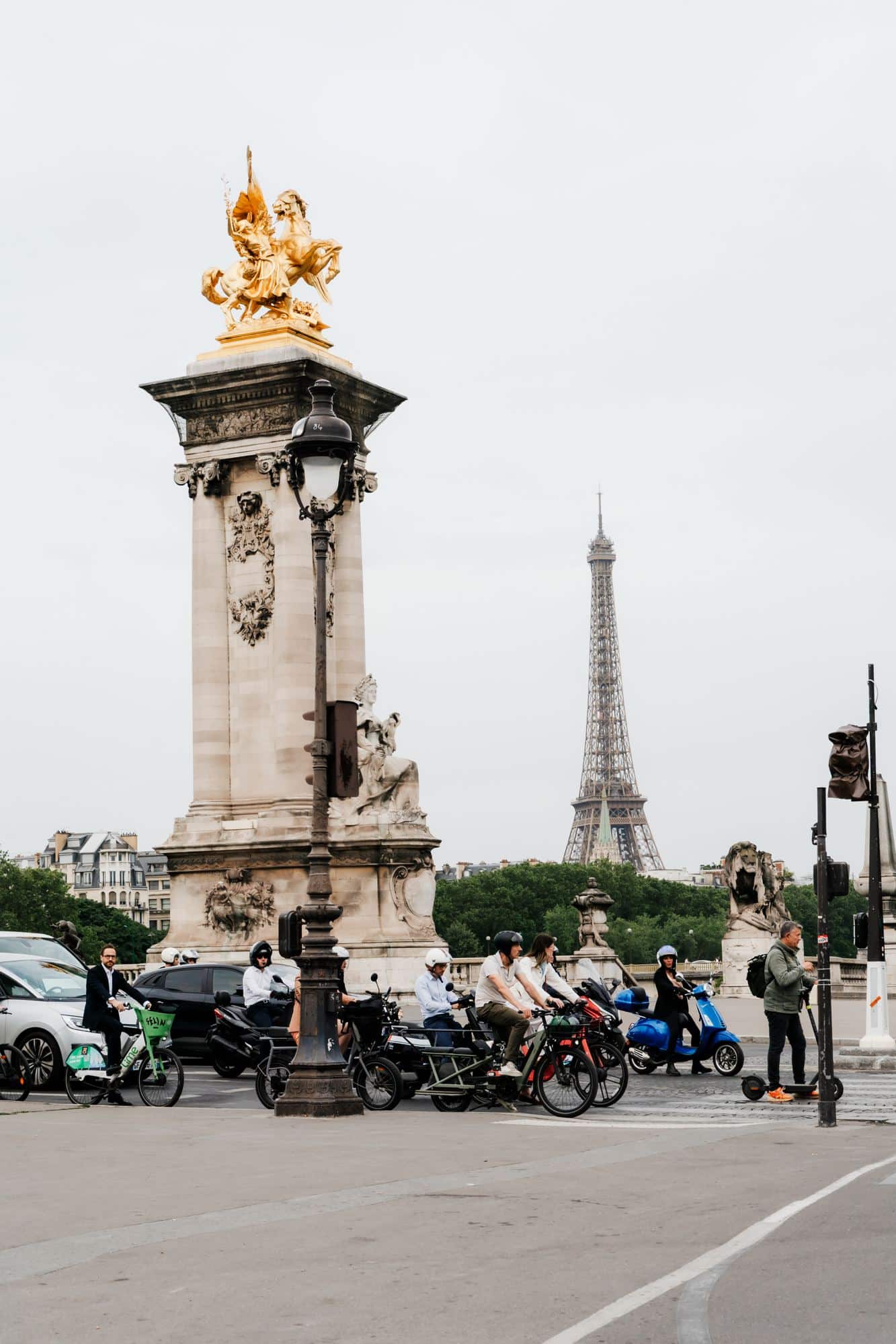 Bride and groom beside a golden lamppost on Pont Alexandre III with the Eiffel Tower behind