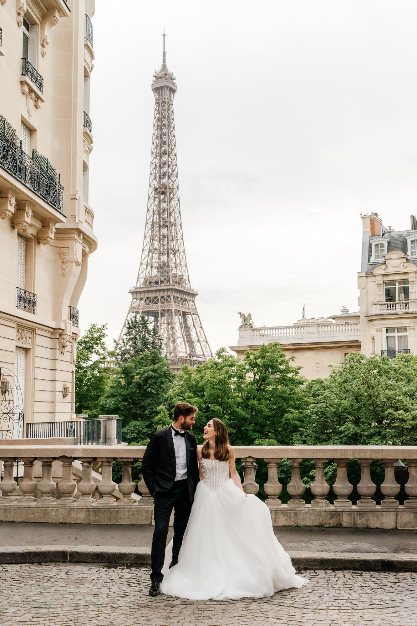 Bride and groom on the Trocadero balustrade with the Eiffel Tower
