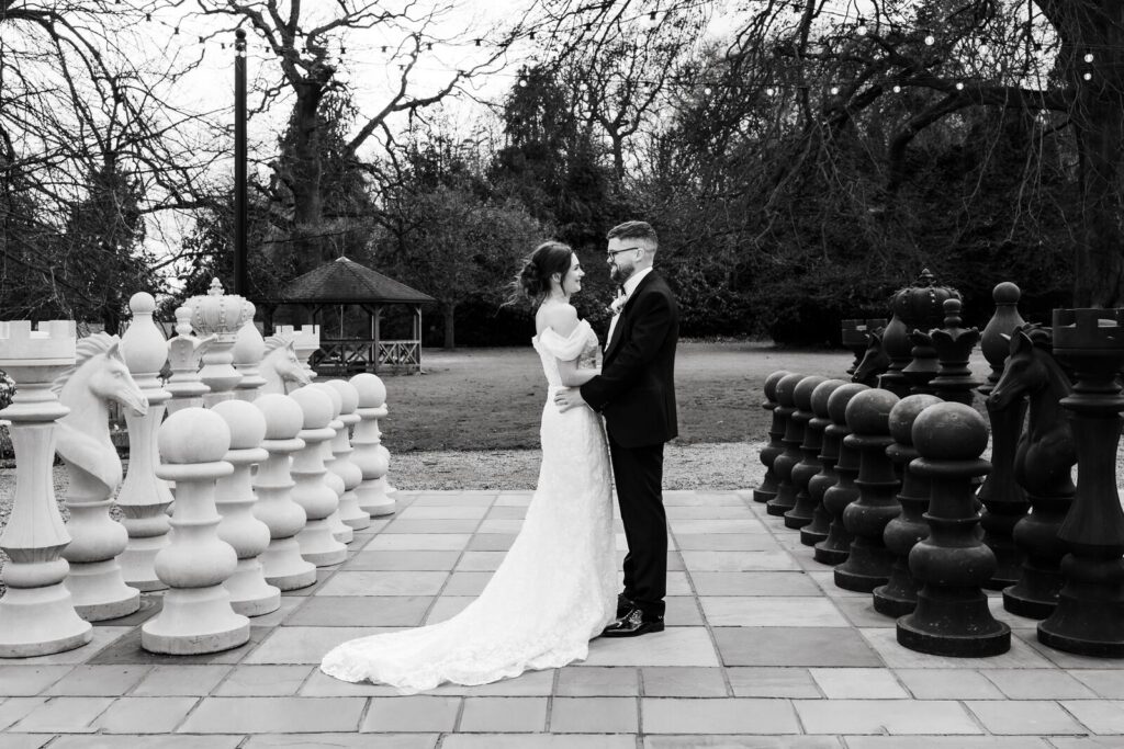 Bride and groom beside the giant chess set at Solberge Hall