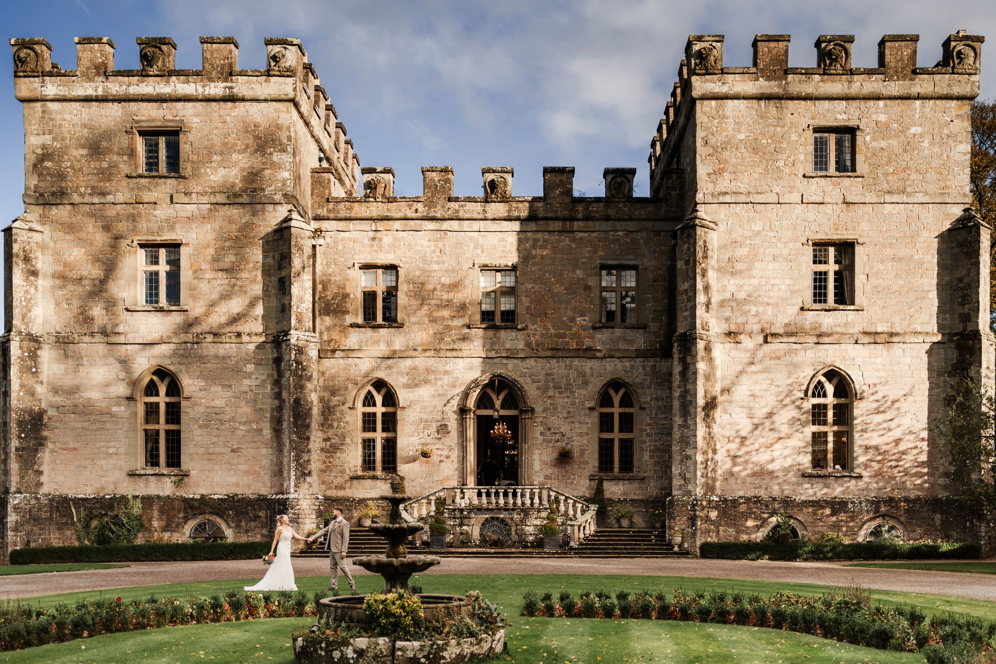 Clearwell Castle courtyard fountain with the couple in the distance