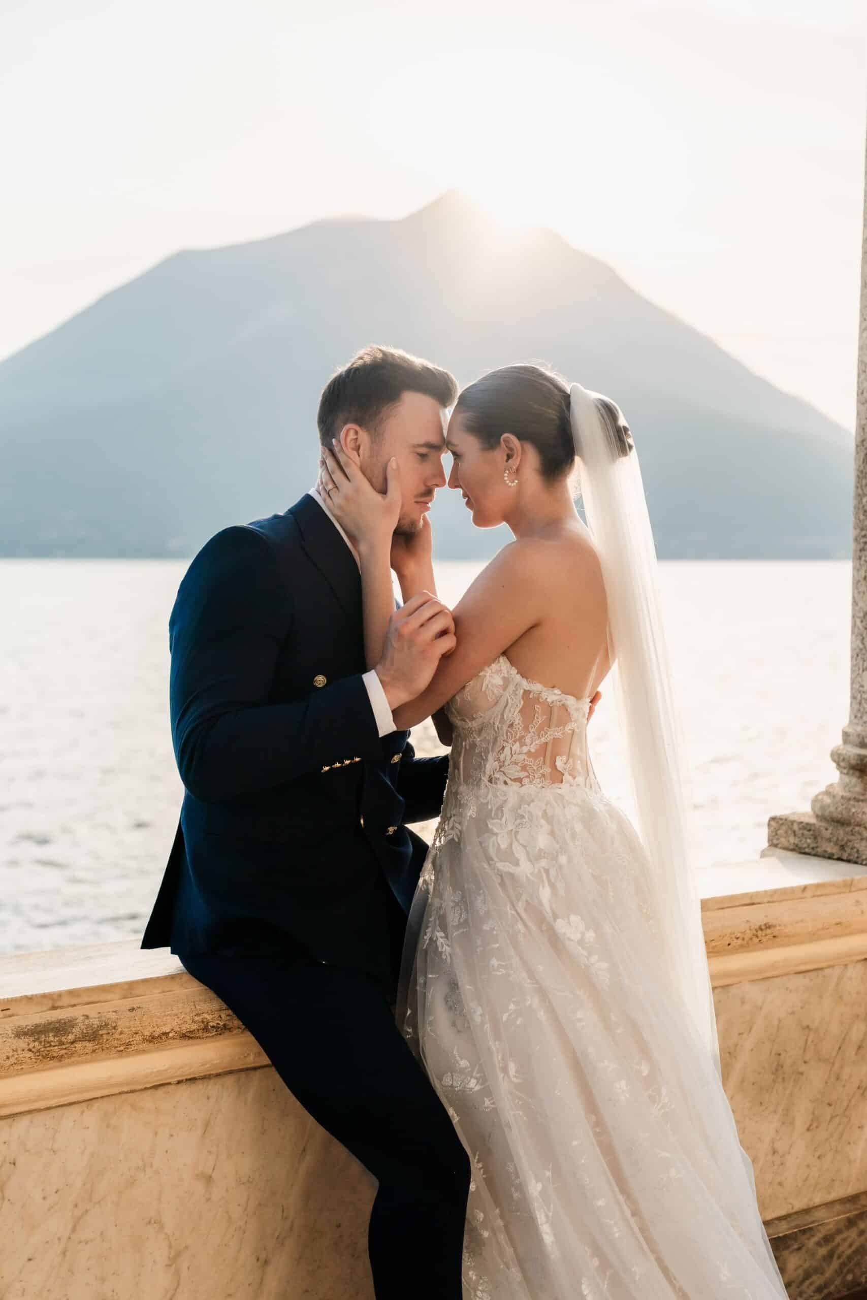 Bride and groom embracing beside Lake Como at Villa Monastero